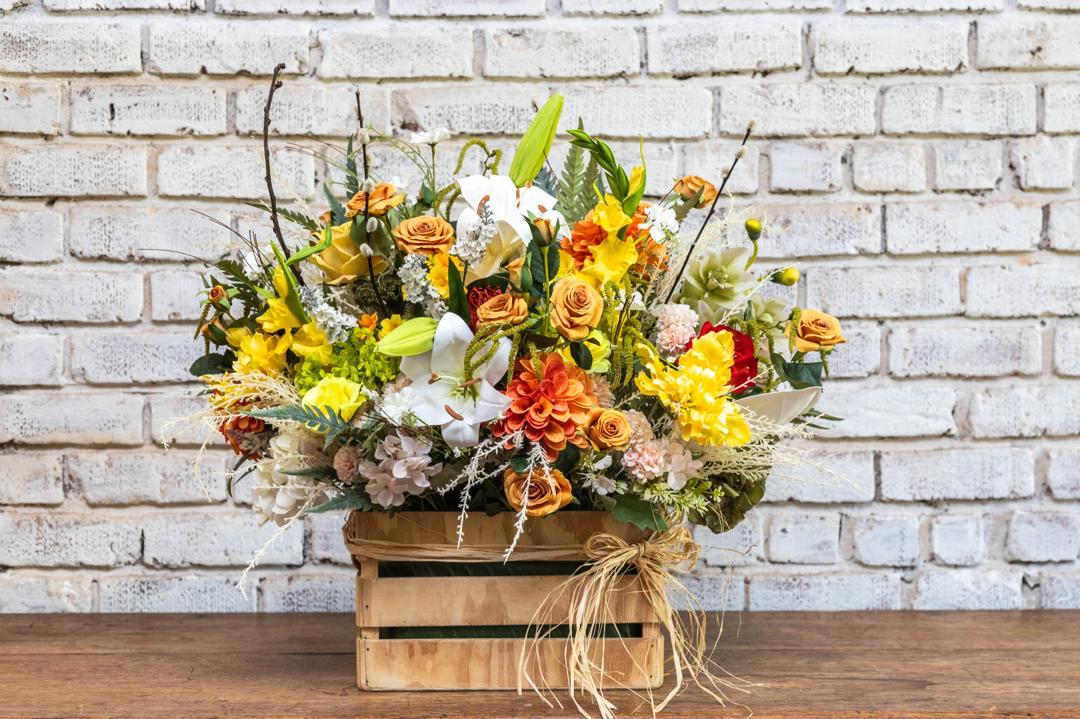 Yellow artificial flower crate arrangement